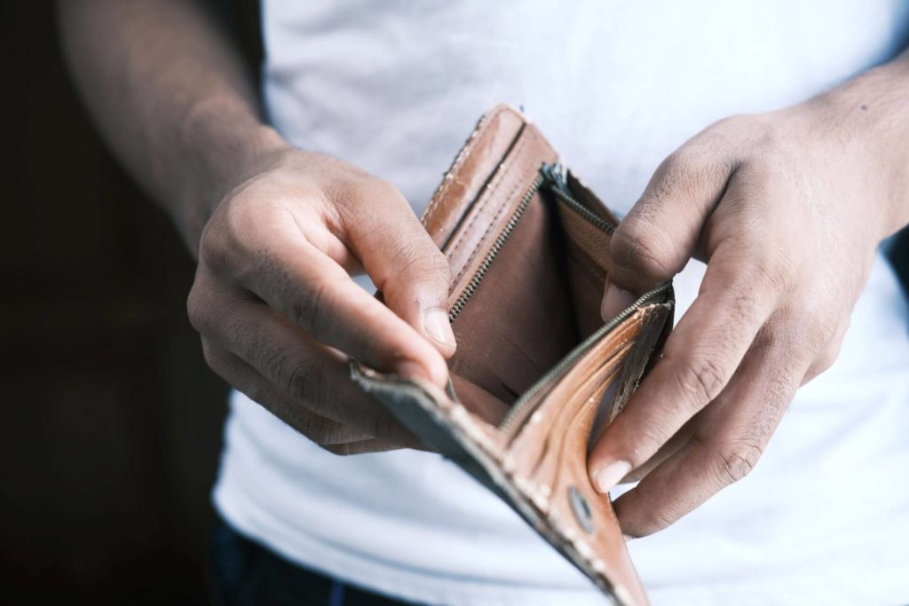 man looking in empty wallet