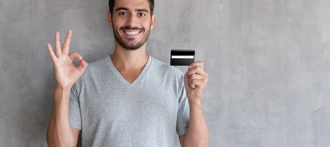 man holding debit card and smiling