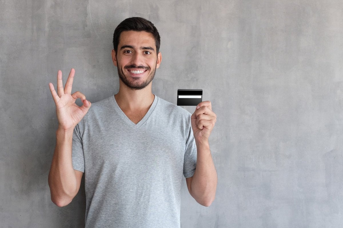 man holding debit card and smiling