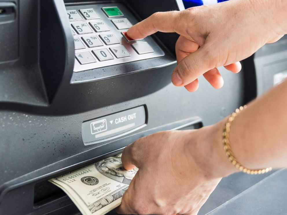 customer using ATM to withdraw money