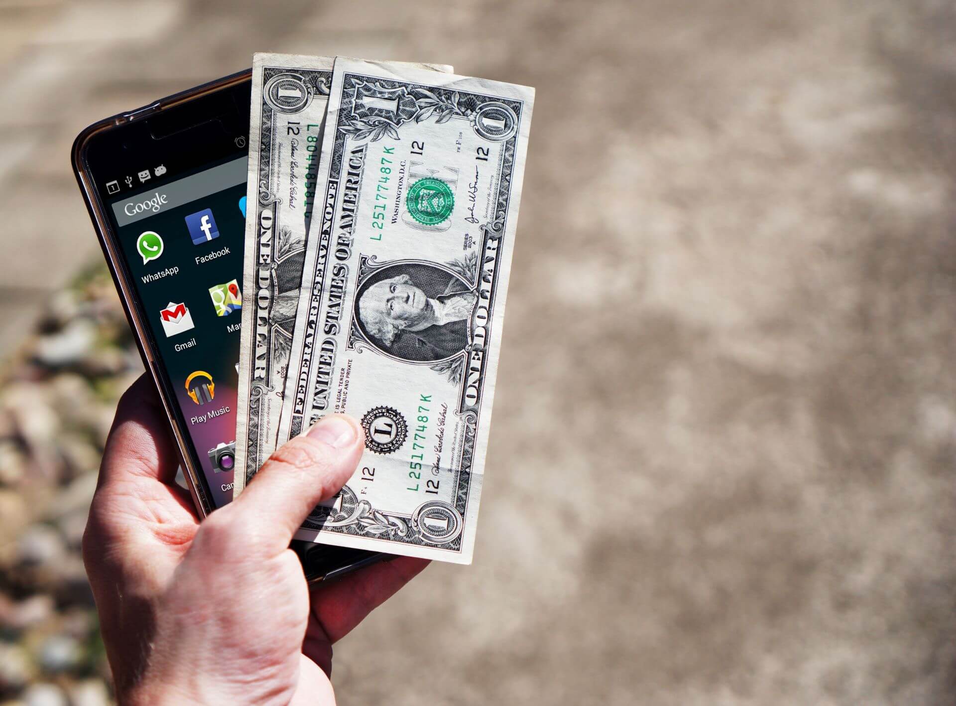 hand holding money and smartphone