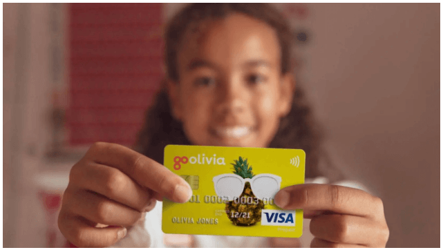 child holding GoHenry debit card
