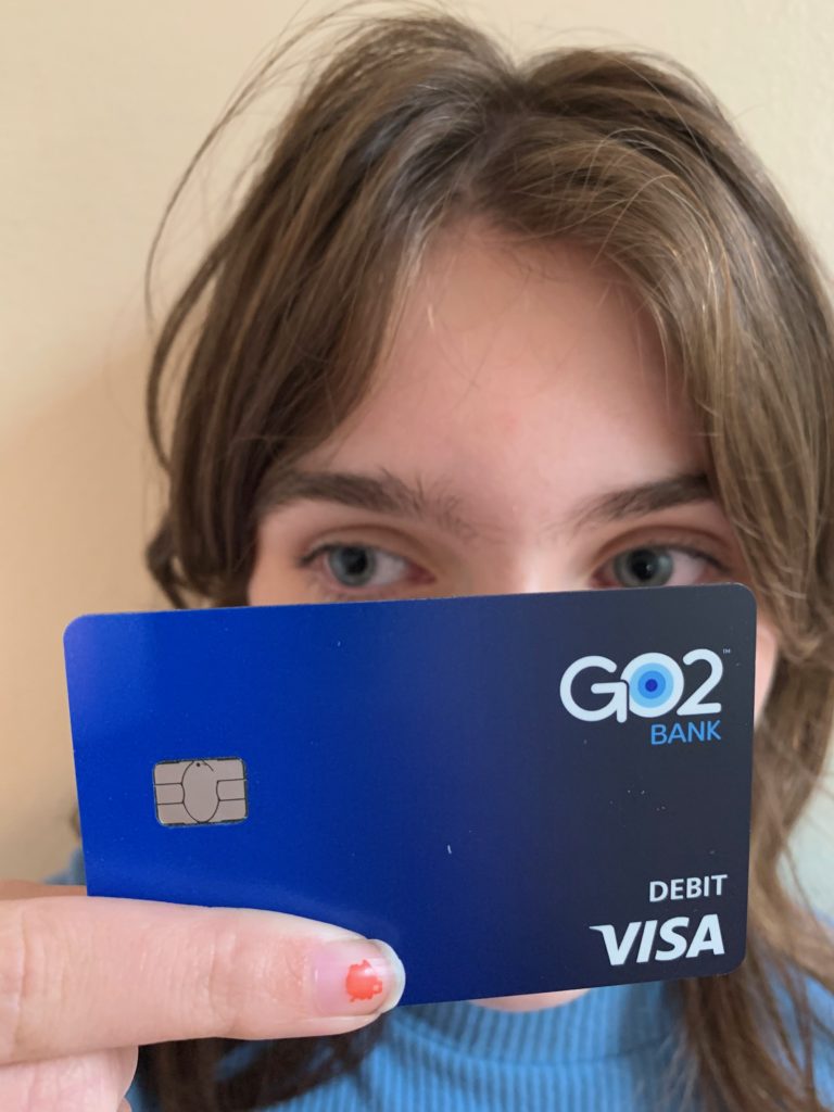 girl holding go2bank debit card