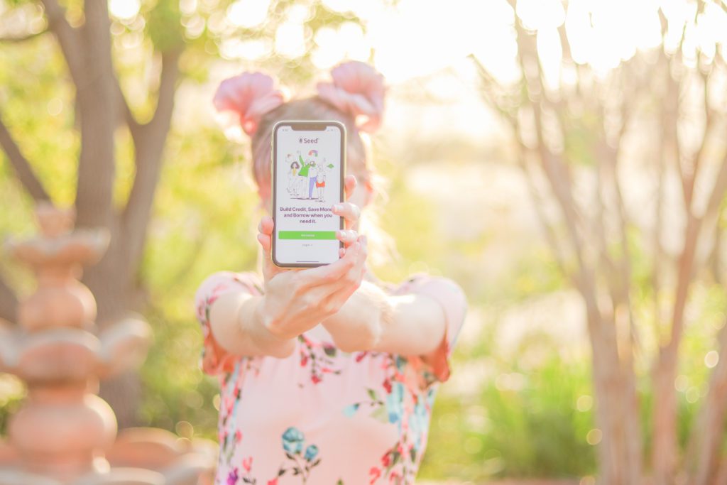 woman holding a phone screen displaying seedfi credit builder loan