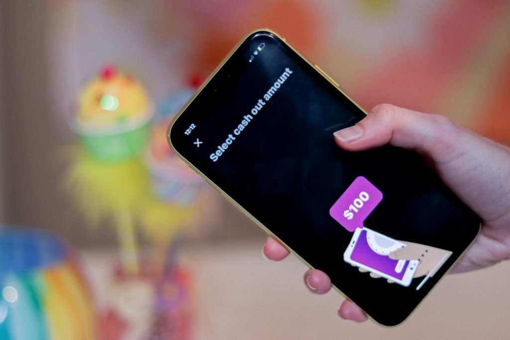 Woman's hand holding a phone that displays a $100 instant loan from Earnin