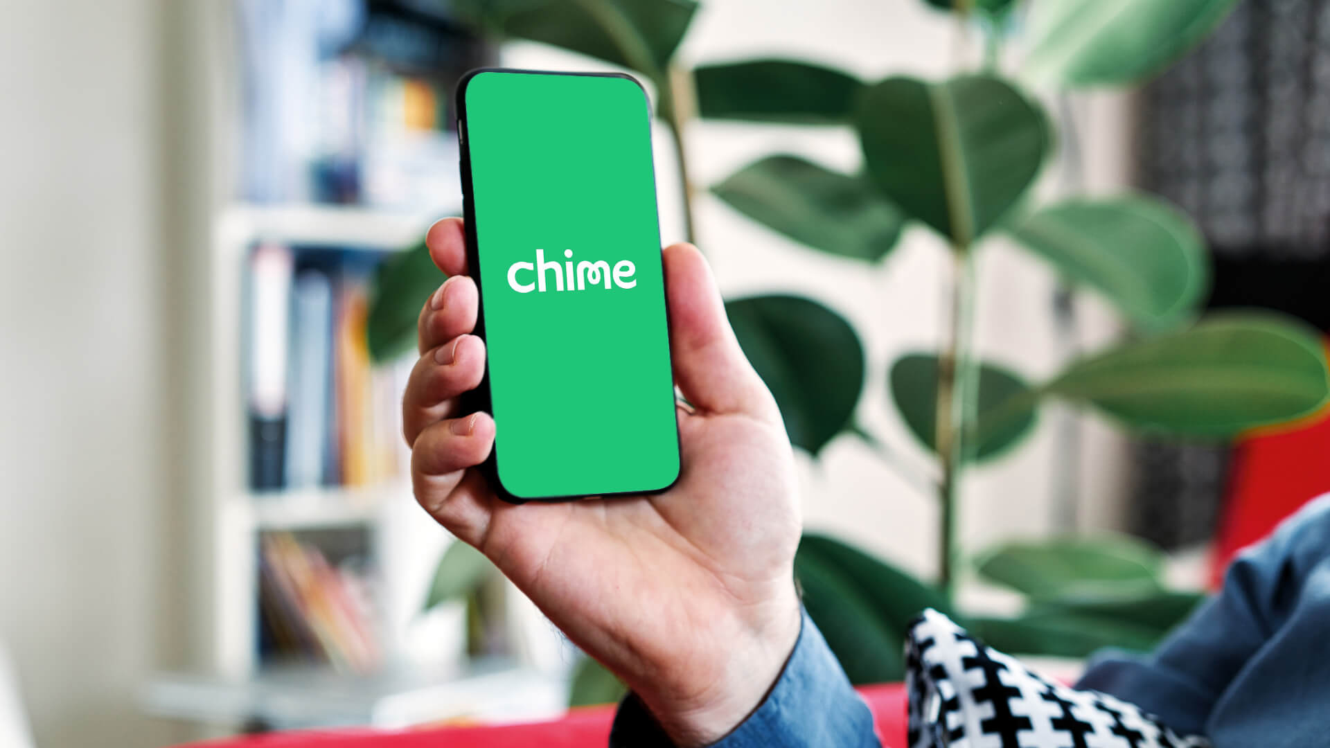 Woman's hand holding a phone that displays the Chime app