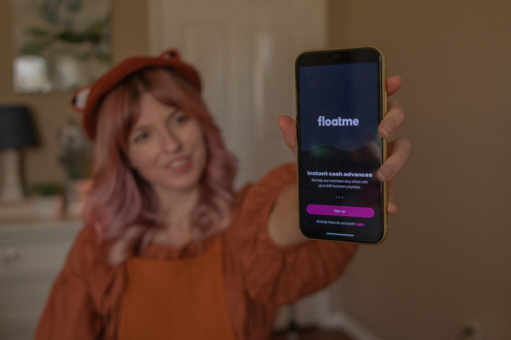 woman holding phone that displays FloatMe app