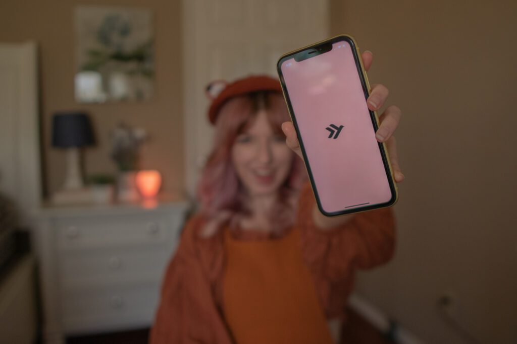 Woman holding phone screen that displays Empower app