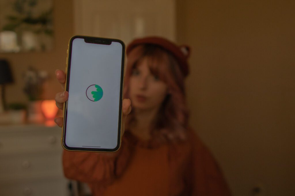 Woman holding up a phone that shows the Vola Finance app