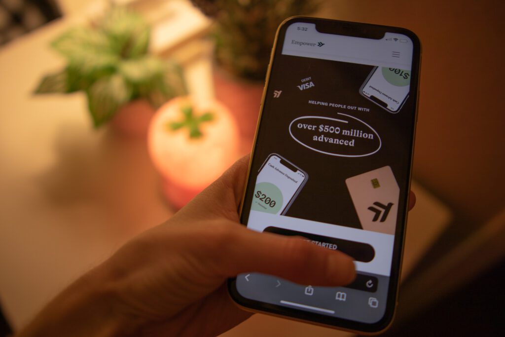 Hand holding phone displaying Empower cash advances