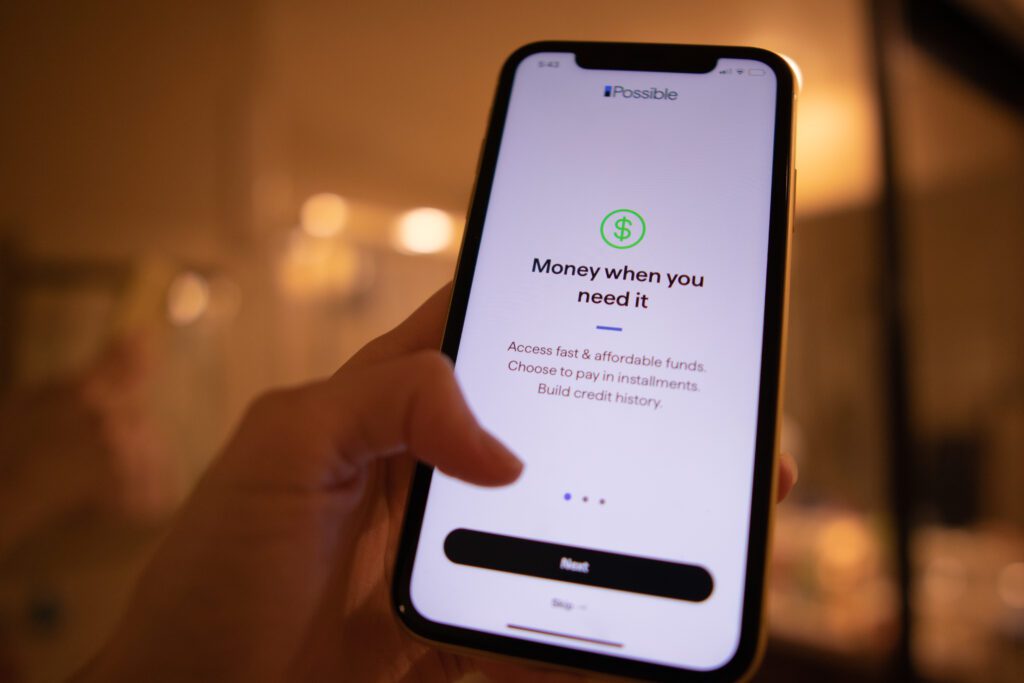 Hand holding phone that displays Possible Finance's loan advertisement