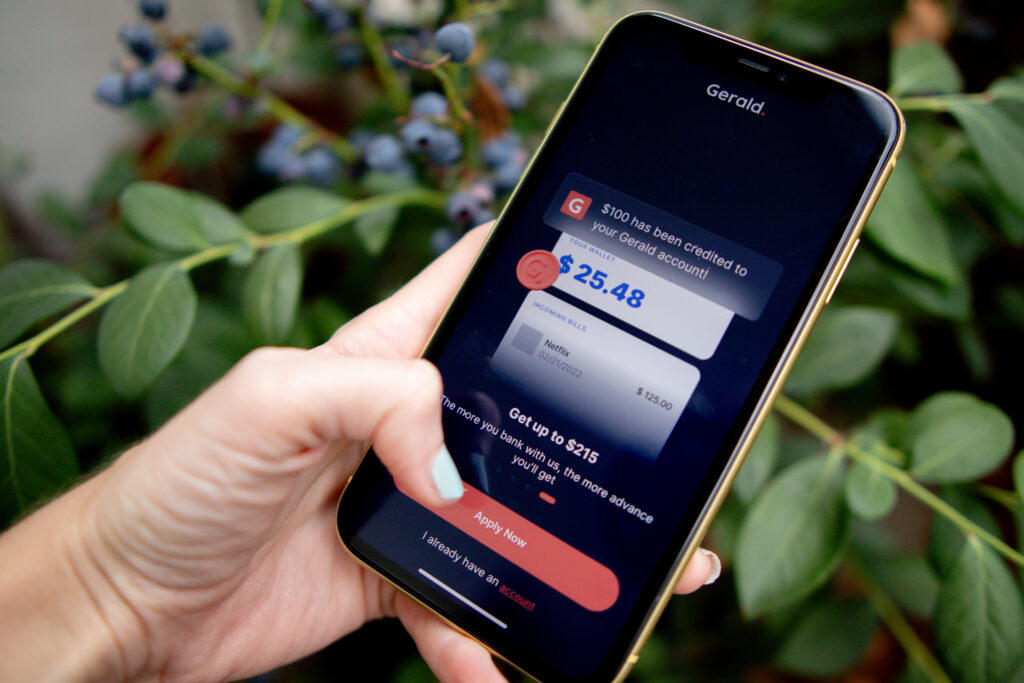 Woman's hand holding phone, while applying for a cash advance on the Gerald app