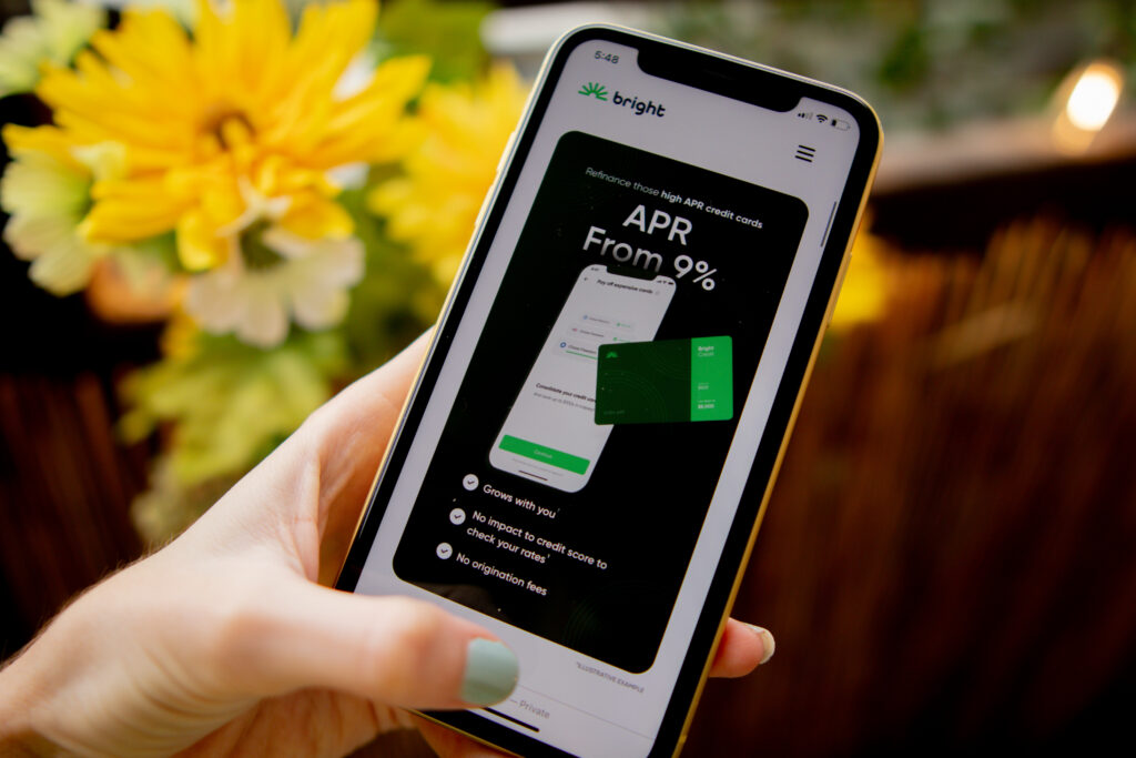 Woman's hand holding phone with intro to Bright lending personal loans